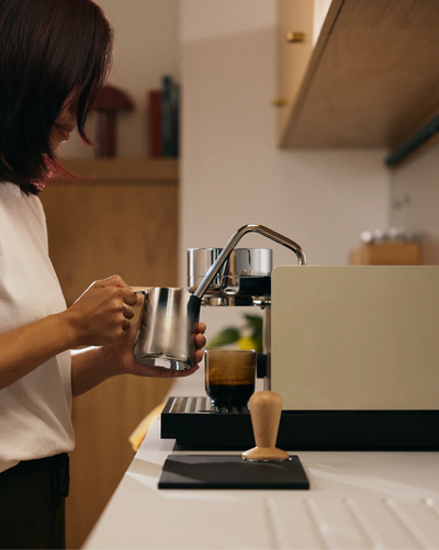 Sesame - Fellow Espresso Series 1 in Sesame color with girl steaming milk using the Fellow Espresso Series 1 espresso machine vellutto.eu